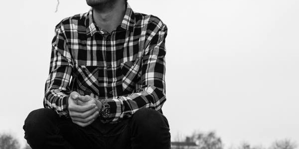 Black and white photo of Producer's Toolbox composer Dan Villalobos sitting in a plaid shirt.