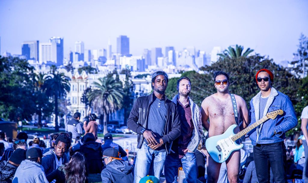 Members of Vinyl Spectrum standing in front of the LA city skyline. 