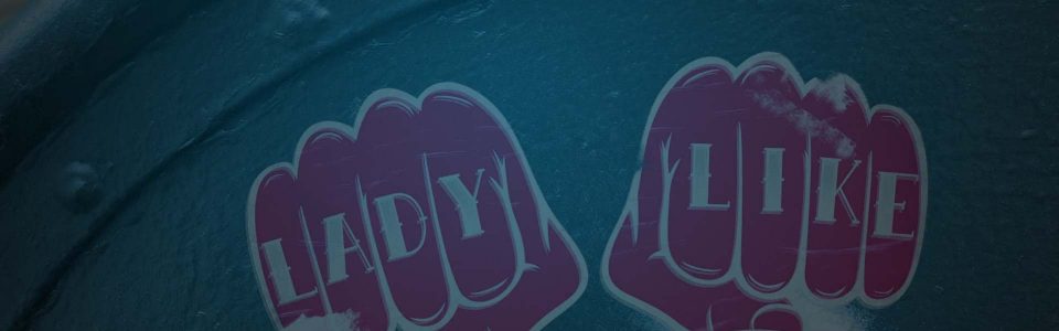 Still of two pink stickers in the shape of fists with the words "Lady Like" written across the knuckles. Flavorlab Sound provided mix for the series.