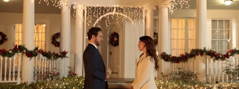 Still from Hallmark's Christmas at Pemberley Manor of Jessica Lowndes and Michael Rady looking at each other in front of a full decorated mansion. Flavorlab Sound provided sound design, voice over recording, and mix for the film.