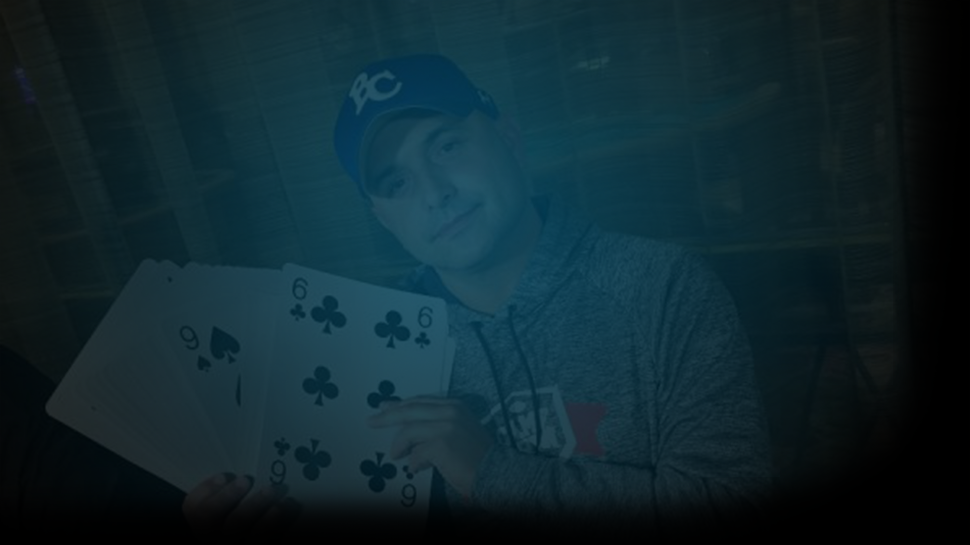 Still of Craig Carton holding giant playing card and looking at the camera in a grey hoodie and blue baseball cap. Flavorlab Score provided original score for documentary, Wildcard, on HBO, about Carton's radio days, double life, and arrest.